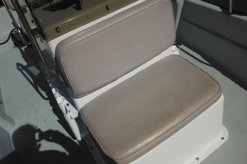 Slide: The Image of Boat seat on a 1999 Maritime Skiff 1690, featuring beige upholstery and white base. - 28