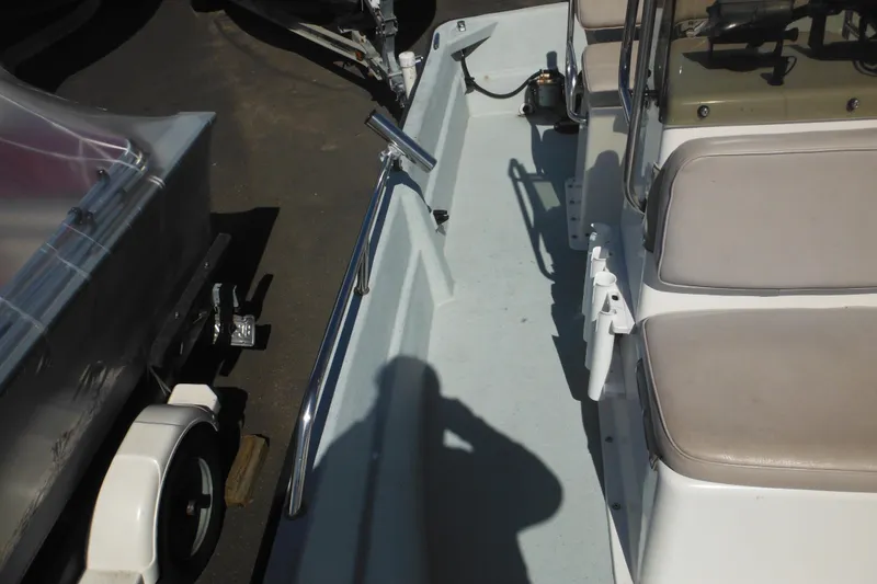 Slide: The Image of 1999 Maritime Skiff 1690 interior with seating and railing, parked on a trailer. - 31