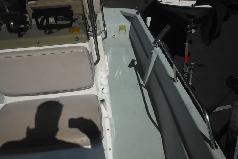 Slide: The Image of 1999 Maritime Skiff 1690 interior with seating and steering wheel, shadow visible on seat. - 32