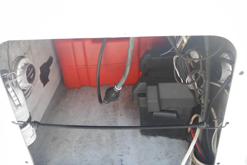 Slide: The Image of Interior view of a 1999 Maritime Skiff 1690, showing wiring and equipment storage. - 35