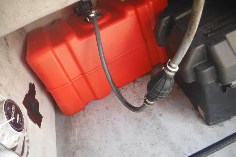 Slide: The Image of Red fuel tank and black battery box inside a 1999 Maritime Skiff 1690 boat. - 36