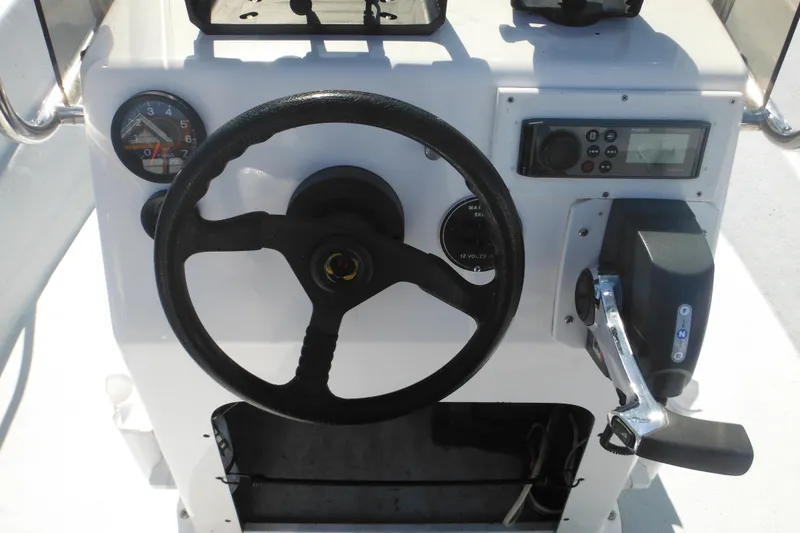 Slide: The Image of 1999 Maritime Skiff 1690 boat dashboard with steering wheel and control panel. - 42