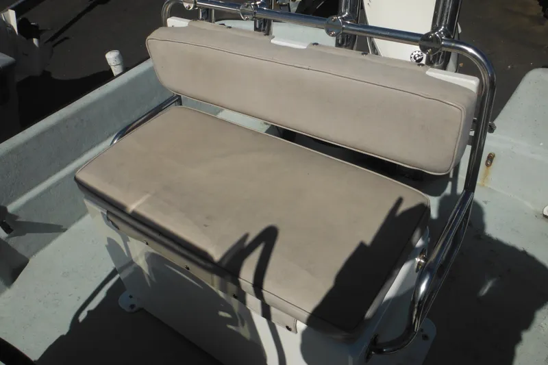 Slide: The Image of 1999 Maritime Skiff 1690 boat seat with beige cushions and metal frame. - 44