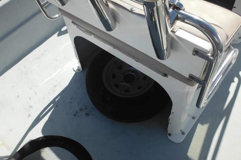 Slide: The Image of 1999 Maritime Skiff 1690 interior with metal railings and spare tire storage. - 45