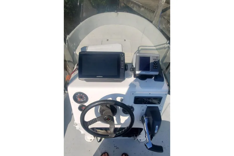 Slide: The Image of 1999 Maritime Skiff 1690 dashboard with Garmin navigation equipment and steering wheel. - 48