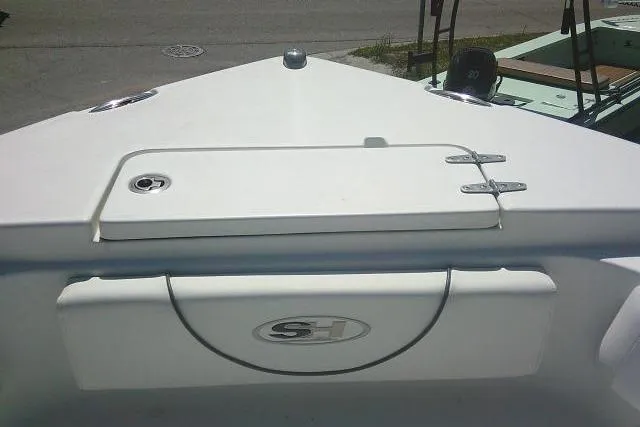 Slide: The Image of 2015 Sea Hunt Ultra 225 boat deck with storage compartment and logo. - 15