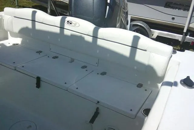 Slide: The Image of 2015 Sea Hunt Ultra 225 boat interior with white seating and storage compartments. - 24