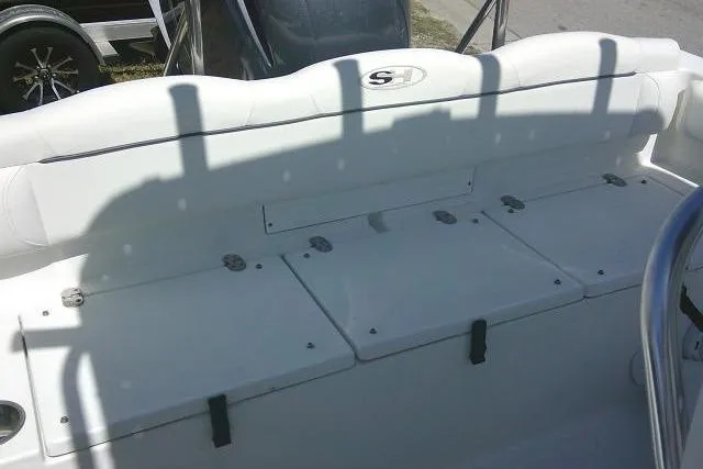 Slide: The Image of 2015 Sea Hunt Ultra 225 boat interior with white seating and storage compartments. - 27
