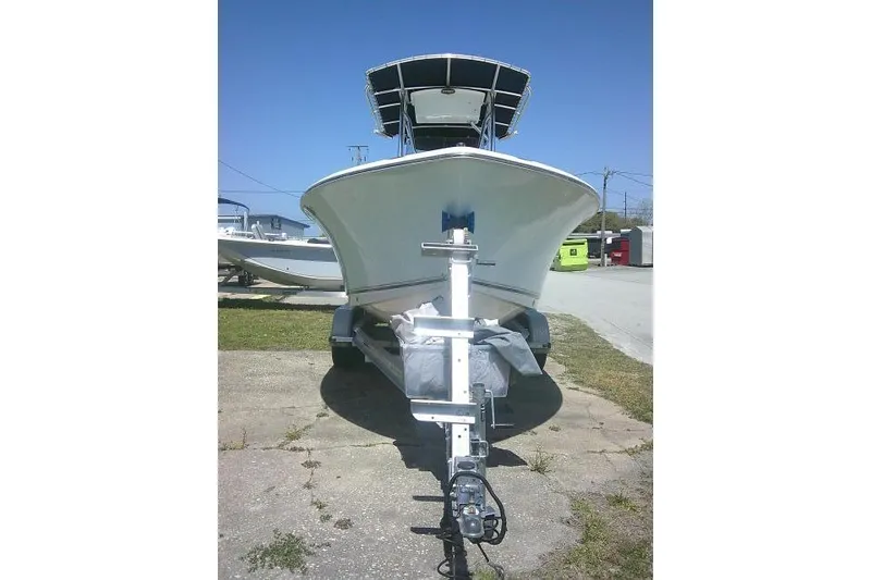 Slide: The Image of 2015 Sea Hunt Ultra 225 boat on trailer, parked outdoors under clear blue sky. - 3