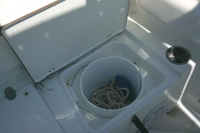 Slide: The Image of 2015 Sea Hunt Ultra 225 boat storage compartment with rope in a bucket. - 31
