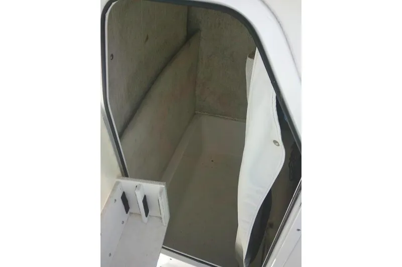 Slide: The Image of 2015 Sea Hunt Ultra 225 boat storage compartment with open door. - 35