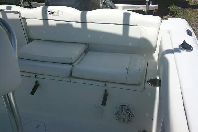 Slide: The Image of 2015 Sea Hunt Ultra 225 boat interior with white cushioned seating and speaker. - 37
