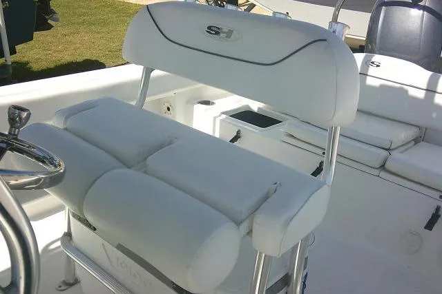 Slide: The Image of 2015 Sea Hunt Ultra 225 boat interior with white cushioned seating and steering wheel. - 49