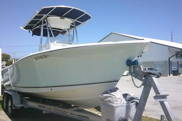 Slide: The Image of 2015 Sea Hunt Ultra 225 boat on trailer, parked outdoors under clear blue sky. - 5