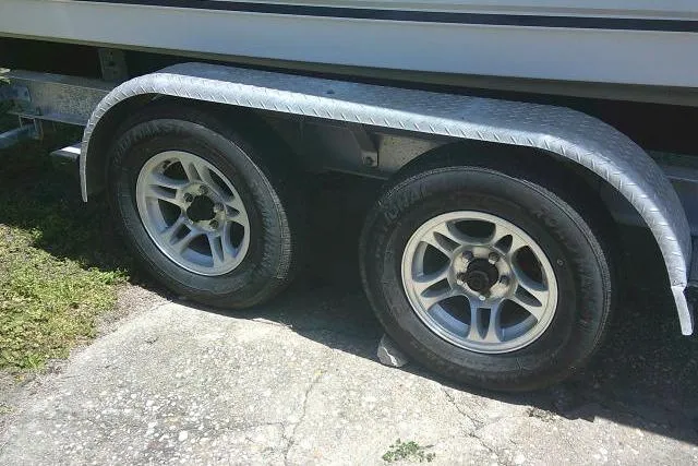 Slide: The Image of Trailer wheels of a 2015 Sea Hunt Ultra 225 boat on a concrete surface. - 52