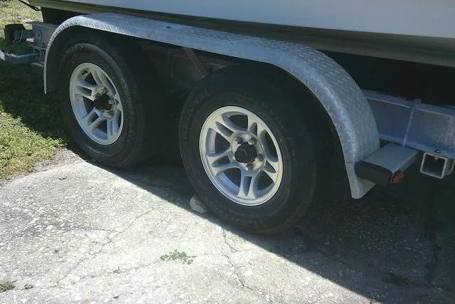 Slide: The Image of Trailer wheels of a 2015 Sea Hunt Ultra 225 boat on a concrete surface. - 7