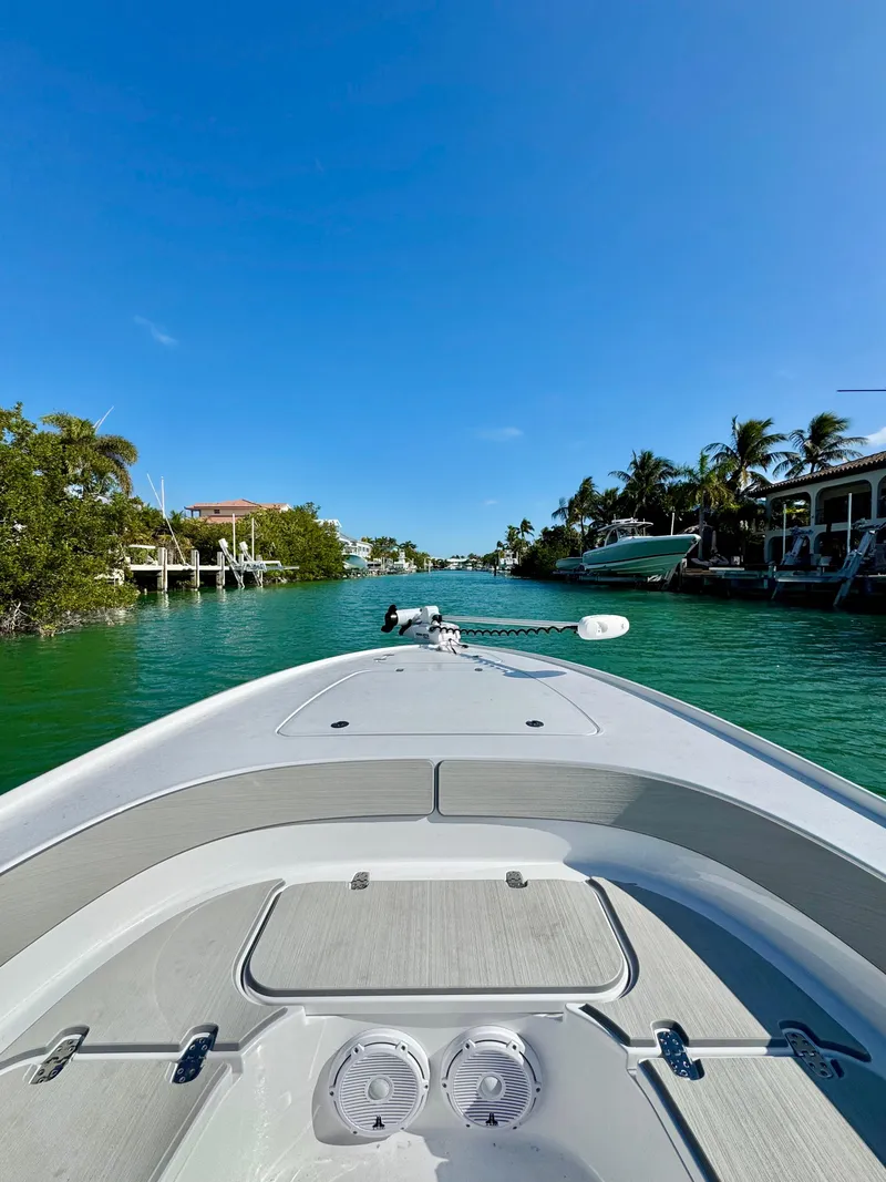 Slide: The Image of 2025 Contender 26 Bay boat cruising on a clear, sunny waterway. - 11