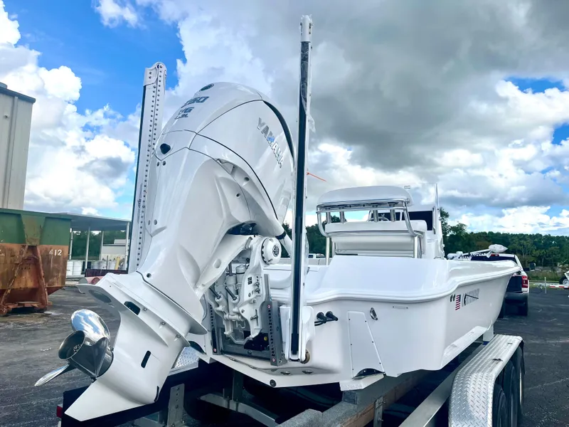 Slide: The Image of 2025 Contender 26 Bay boat on trailer under cloudy sky. - 5