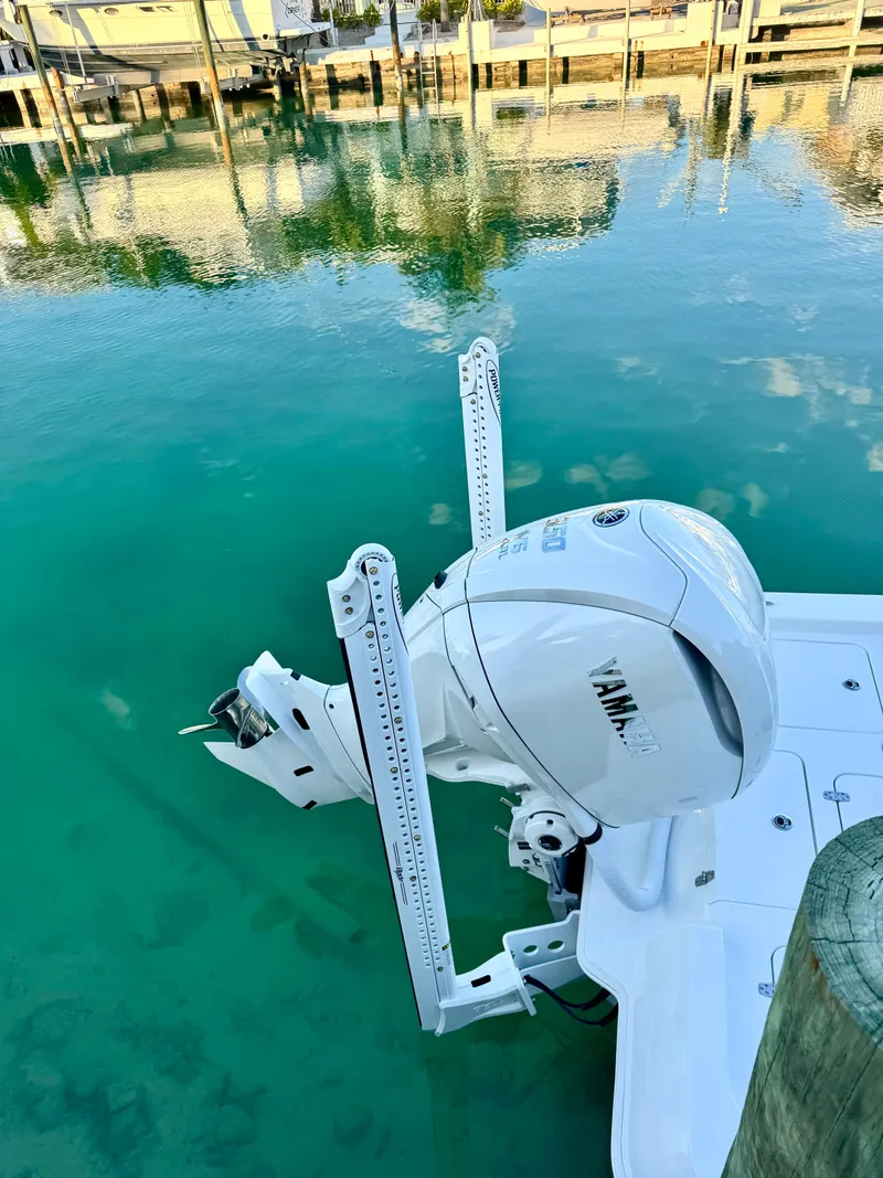 Slide: The Image of 2025 Contender 26 Bay boat with Yamaha engine in clear turquoise water. - 6