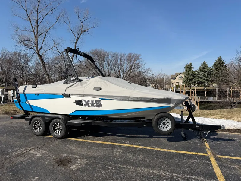Slide: The Image of 2020 Axis A20 boat on trailer, covered, parked outdoors. - 20