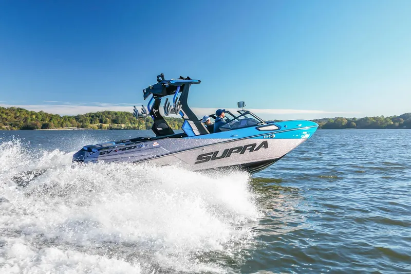 Slide: The Image of 2024 Supra SV 400 boat cruising on a lake under clear blue skies. - 1