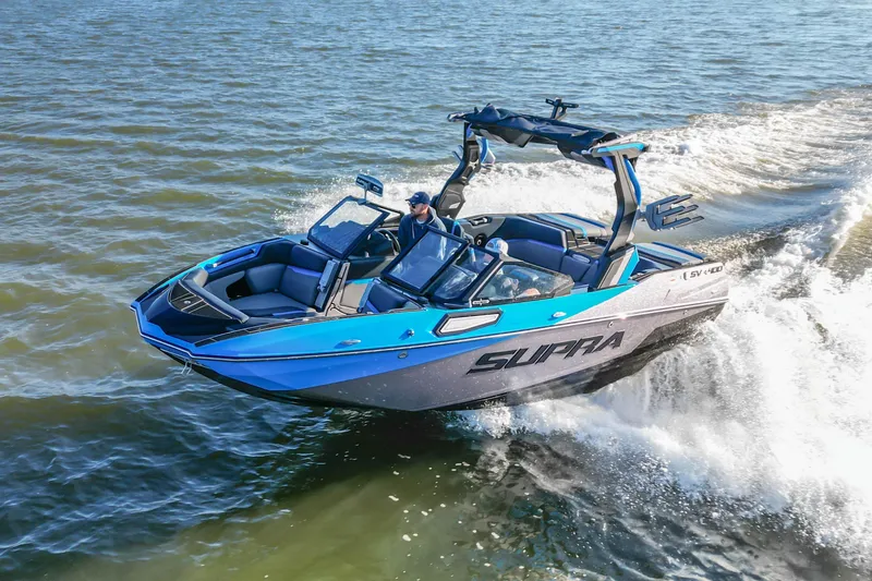 Slide: The Image of 2024 Supra SV 400 boat cruising on water, showcasing sleek design and vibrant blue accents. - 6
