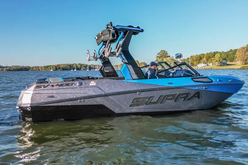 Slide: The Image of 2024 Supra SV 400 boat on a lake, featuring sleek design and vibrant blue accents. - 8