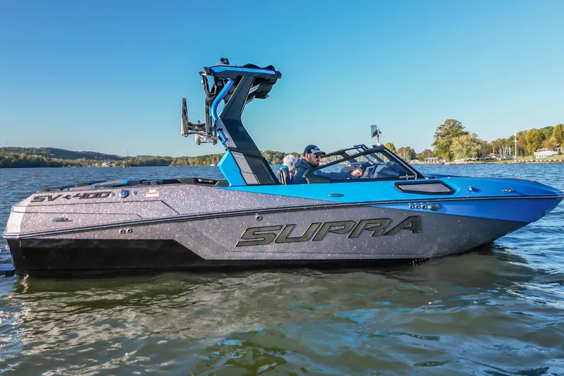Slide: The Image of 2024 Supra SV 400 boat cruising on a serene lake under a clear blue sky. - 9