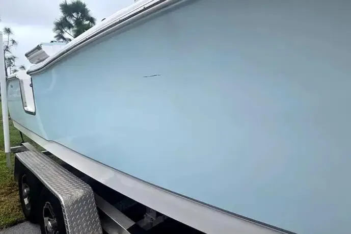 Slide: The Image of 2025 Sea Hunt Ultra 255 SE boat on trailer, side view, light blue hull. - 14