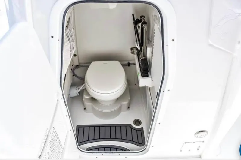 Slide: The Image of 2025 Sea Hunt Ultra 255 SE boat interior with compact marine toilet. - 18