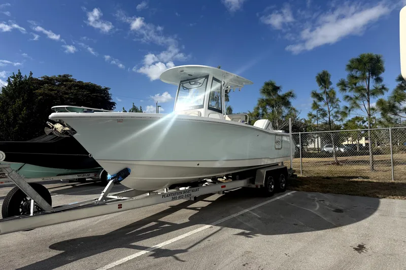 Slide: The Image of 2025 Sea Hunt Ultra 255 SE boat on trailer under clear blue sky. - 3