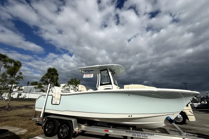 Slide: The Image of 2025 Sea Hunt Ultra 255 SE boat on trailer under cloudy sky. - 4
