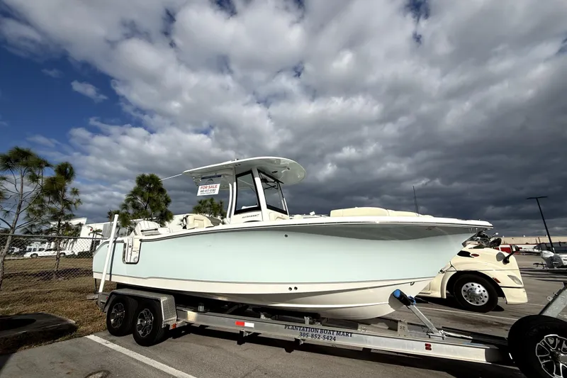 Slide: The Image of 2025 Sea Hunt Ultra 255 SE boat on trailer, parked under cloudy sky. - 5