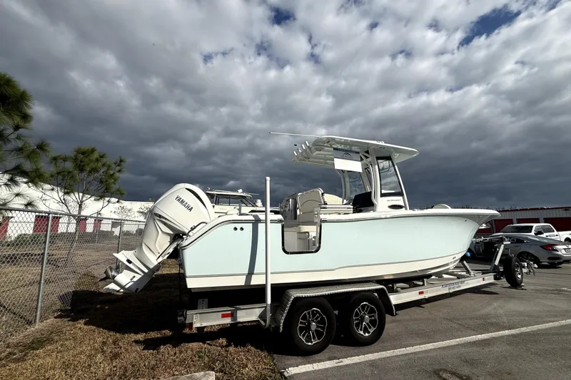 Slide: The Image of 2025 Sea Hunt Ultra 255 SE boat on trailer under cloudy sky. - 6