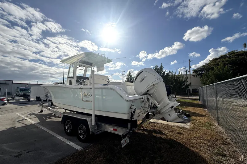 Slide: The Image of 2025 Sea Hunt Ultra 255 SE boat on trailer under sunny sky. - 7