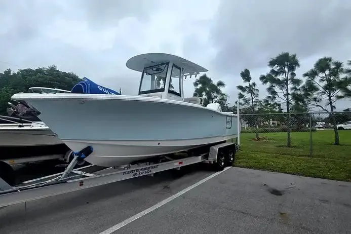 Slide: The Image of 2025 Sea Hunt Ultra 255 SE boat on trailer, parked outdoors, cloudy sky background. - 8