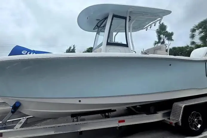 Slide: The Image of 2025 Sea Hunt Ultra 255 SE boat on trailer, side view, light blue hull. - 9