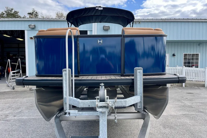 Slide: The Image of Harris Sunliner 250 pontoon boat 2026 on trailer outside warehouse. - 3