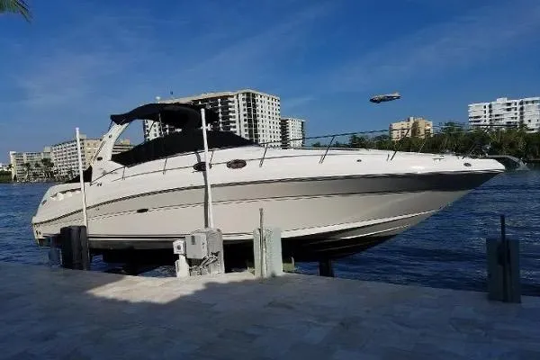 The Image of 2008 Sea Ray 340 Sundancer yacht docked by waterfront with cityscape background. - 0