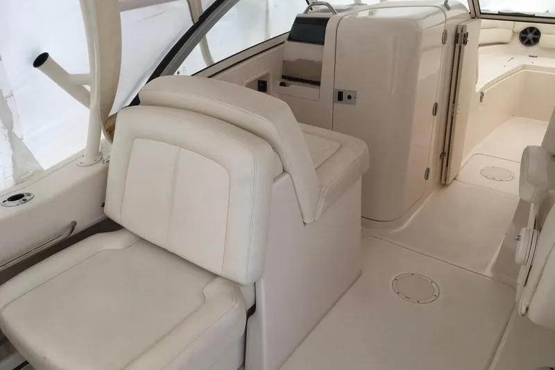 Slide: The Image of 2019 Grady-White Freedom 235 boat interior with beige seating and helm area. - 18