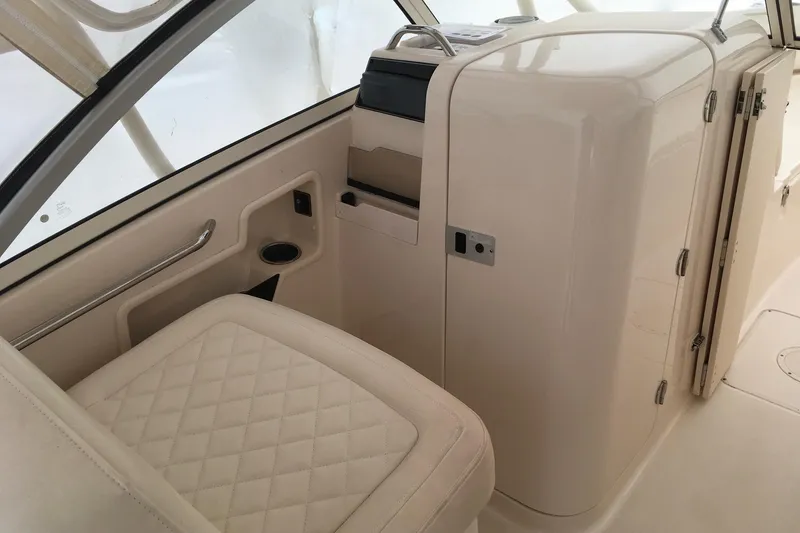 Slide: The Image of Interior of 2019 Grady-White Freedom 235 boat, featuring cushioned seating and storage area. - 7