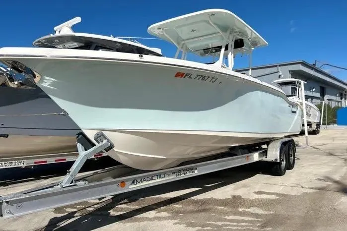 The Image of 2023 Key West 263 FS boat on trailer under clear blue sky. - 1
