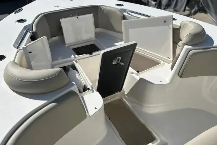 Slide: The Image of 2023 Key West 263 FS boat interior with open storage compartments and cushioned seating. - 10