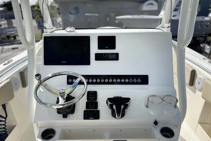 Slide: The Image of 2023 Key West 263 FS boat dashboard with steering wheel and electronic controls. - 21