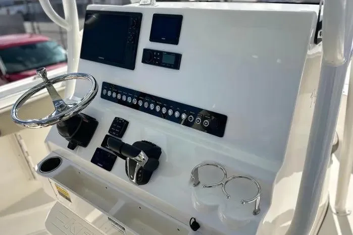 Slide: The Image of 2023 Key West 263 FS boat dashboard with steering wheel and electronic controls. - 23