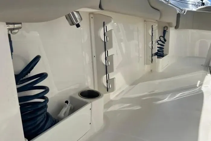Slide: The Image of 2023 Key West 263 FS boat interior with rod holders and coiled hoses. - 34