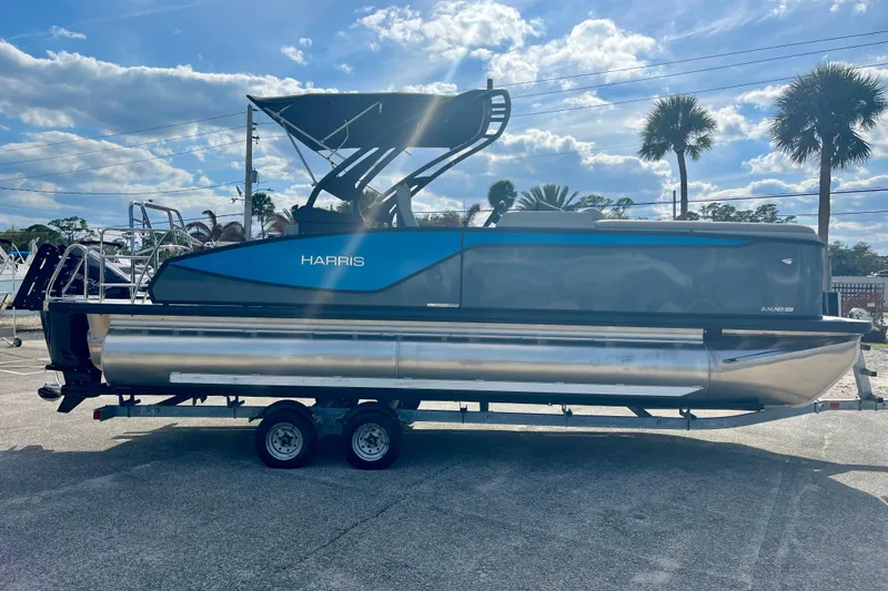 Slide: The Image of Harris Sunliner 230 Sport 2026 on trailer, blue sky, palm trees in background. - 5