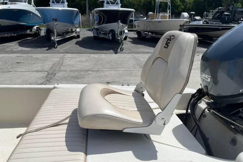 Slide: The Image of 2015 Carolina Skiff JV15CC boat seat and motor in a marina setting. - 11