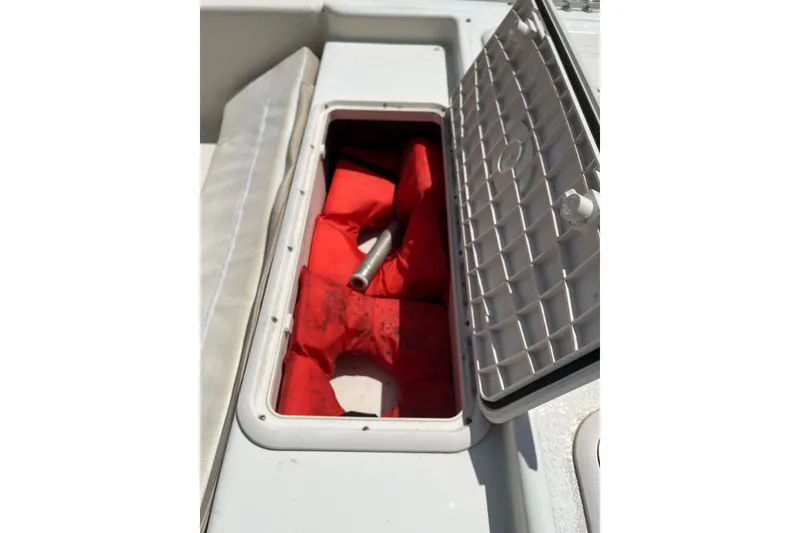 Slide: The Image of Open storage compartment on 2015 Carolina Skiff JV15CC with red life jackets inside. - 13