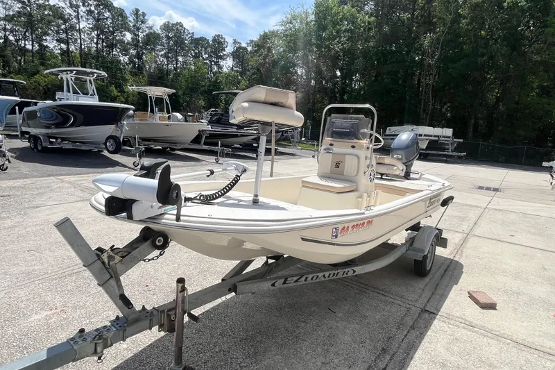 Slide: The Image of 2015 Carolina Skiff JV15CC boat on trailer, parked outdoors with other boats nearby. - 5